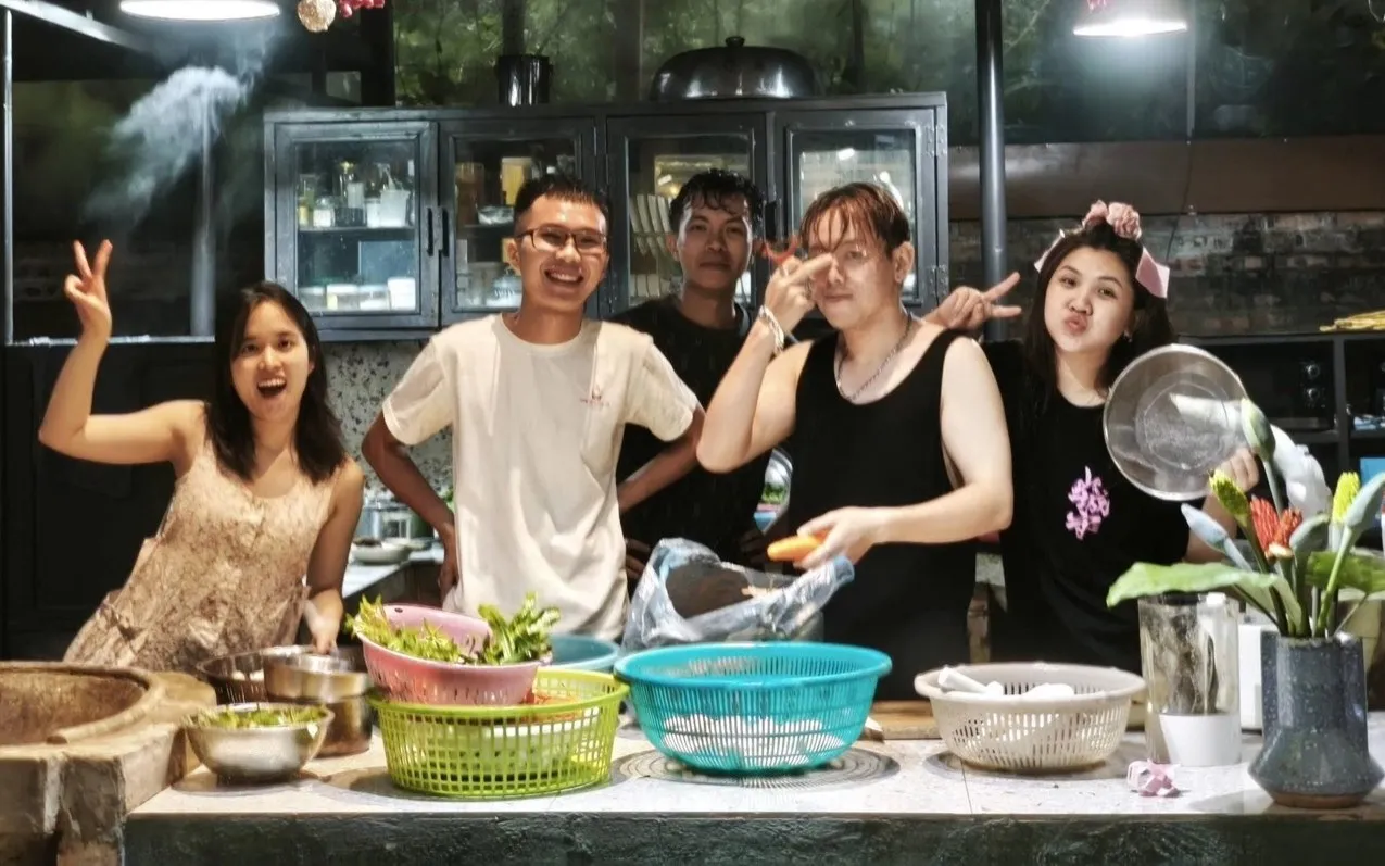 Cả nhóm đứng bên bàn bếp giữa rổ rau vừa nhặt xong sau bữa nấu chung